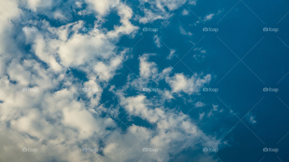 Large clouds float across the sunset sky like sails.