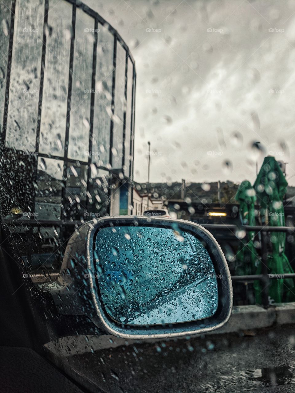 Top view of wet window of the car with big rain drops in rainy autumn cold day close up. Weather.