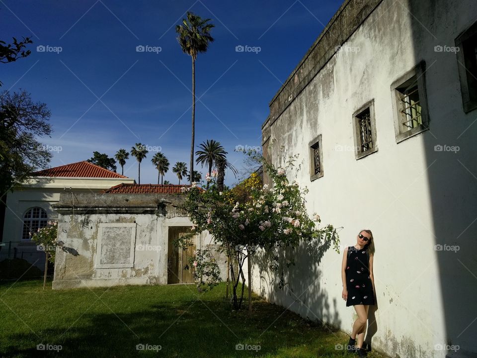 A botanical garden in lisbon. Girl standing against a white wall