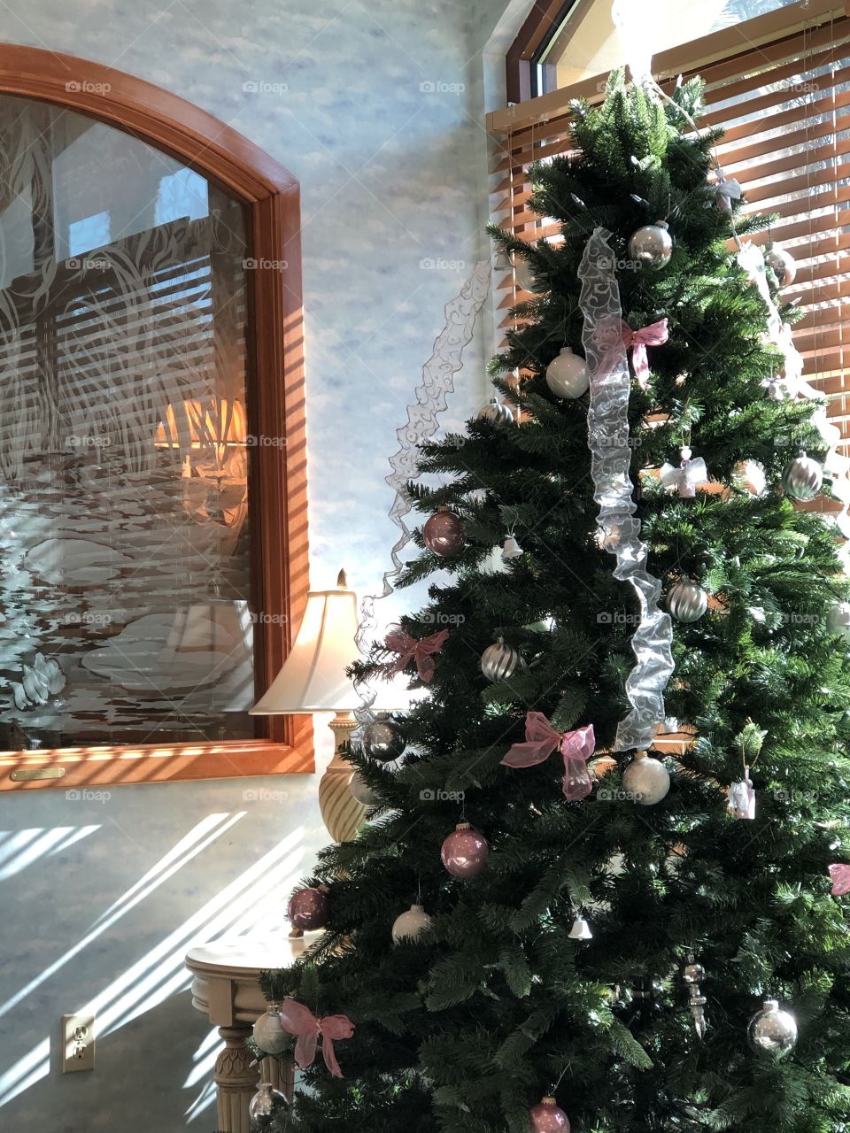 Treating sun through blinds with lamp near Christmas Tree