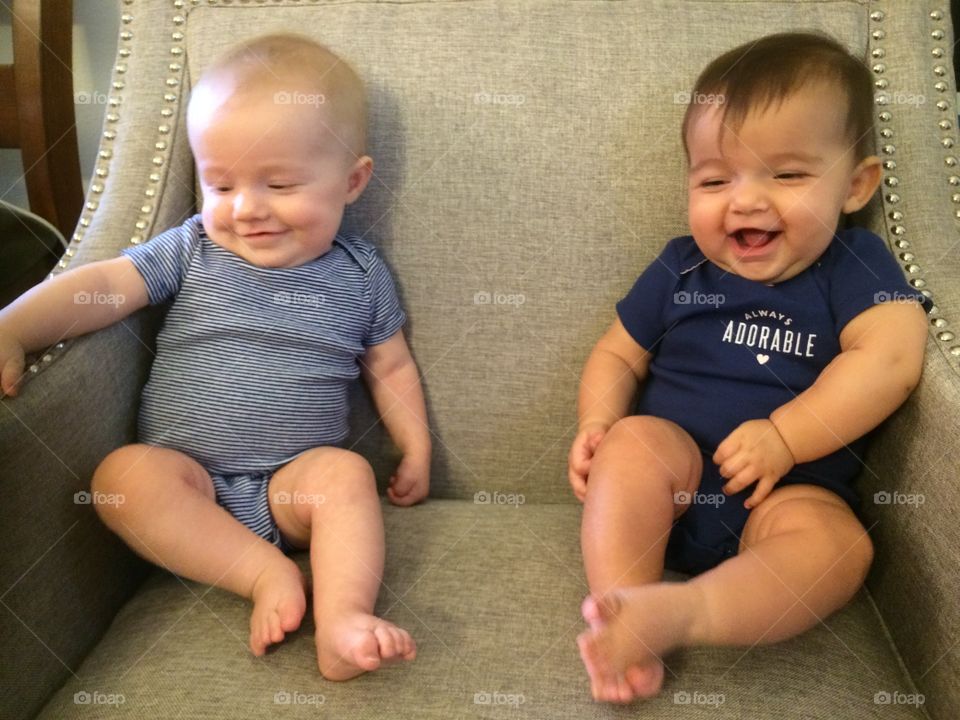 Twin baby girls laughing while trying to take their photo
