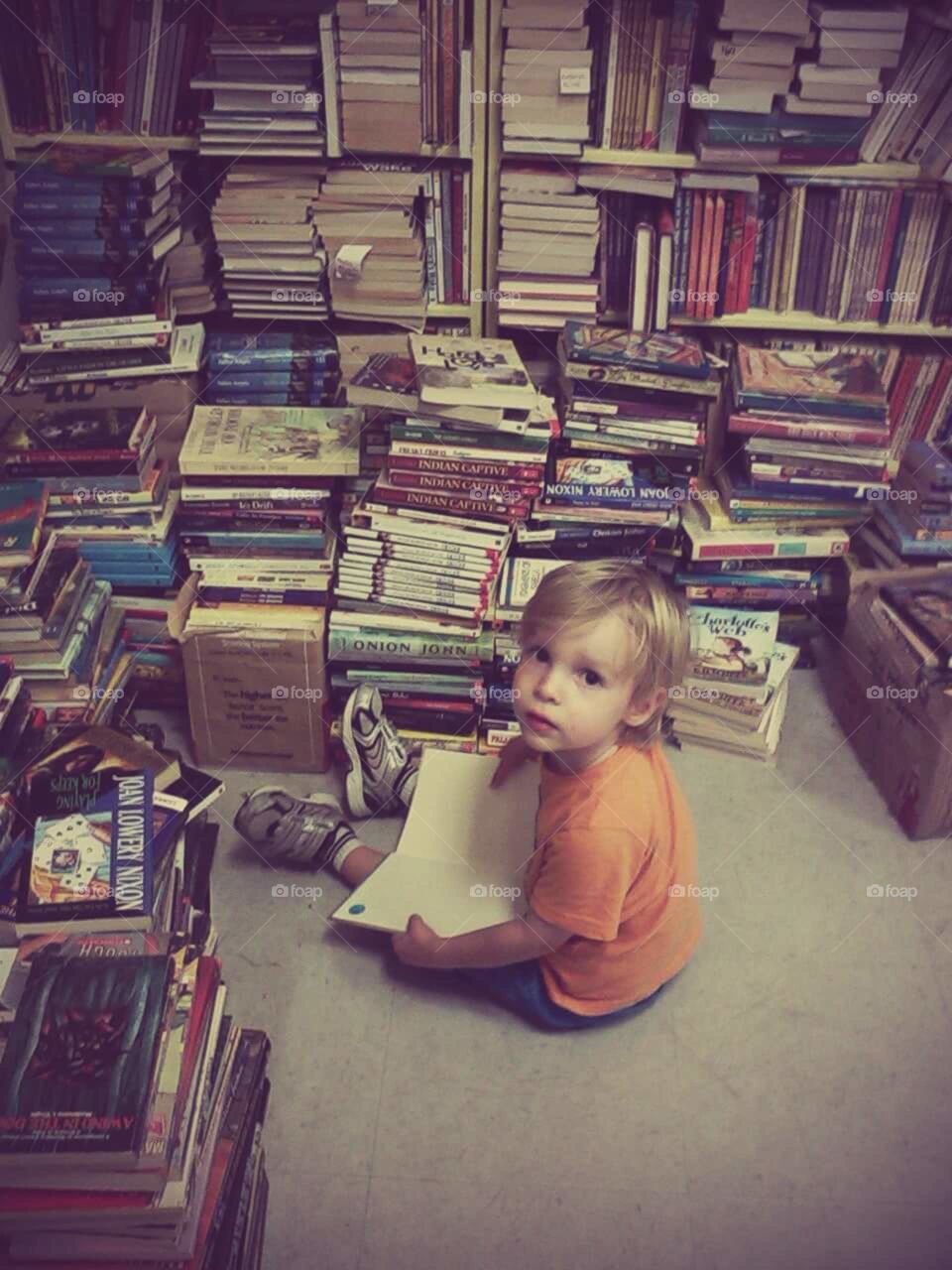 toddler with lots of books
