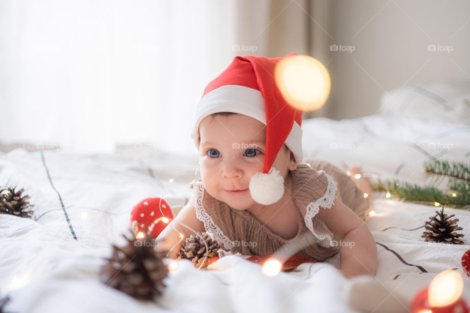 Little cute infant girl in santas red hat 
