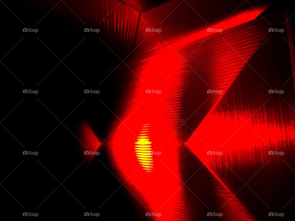 An abstract geometric red pattern created by an electric candle light, and translucent red panels.  