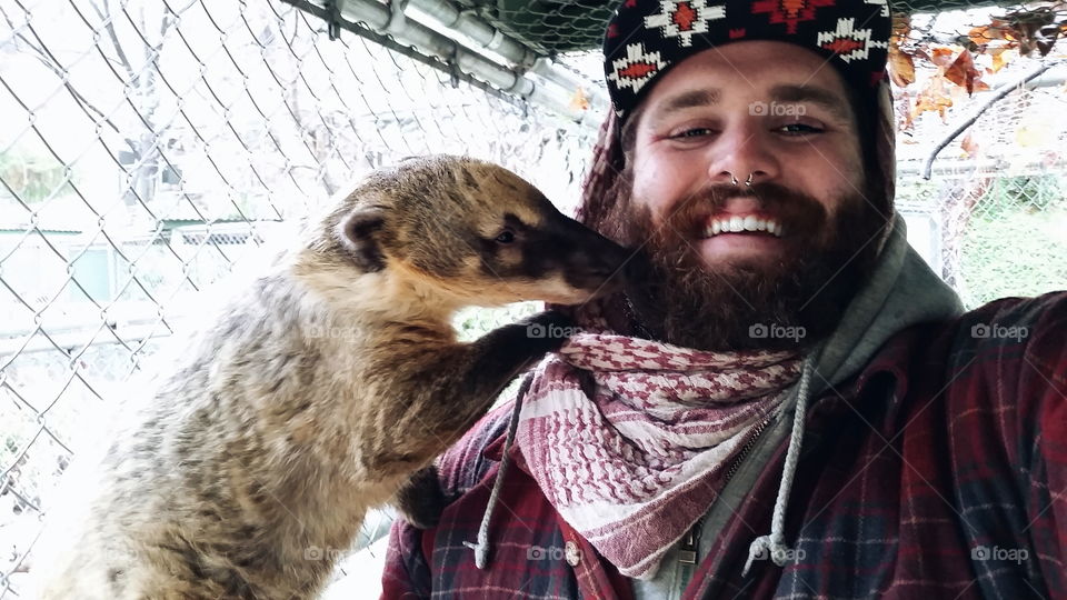 Close-up of a happy man with meerkat
