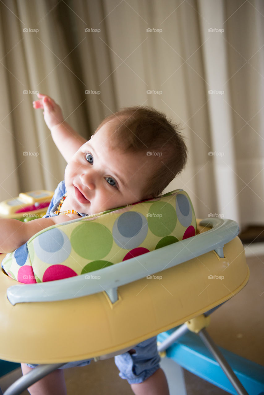 Cute baby girl sitting on crib