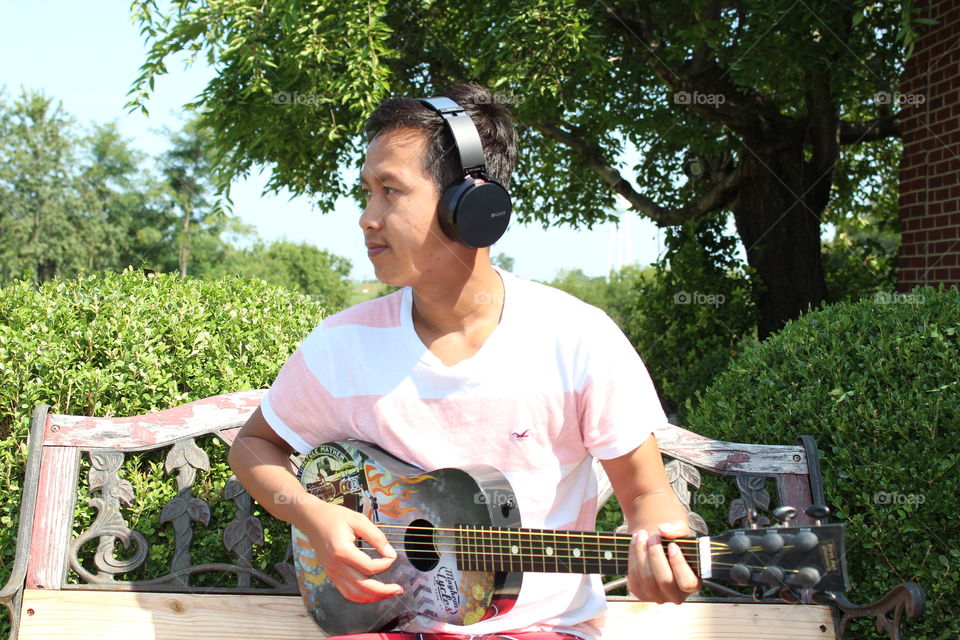 Young man playing guitar outside 