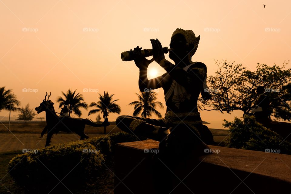 Silhouette statue in public parks and sunrise background
