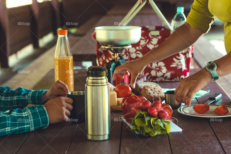 Preparing and eating a breakfast outdoor during spending vacation on camping