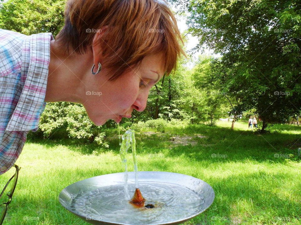 girl drinking water from a drinking fountain