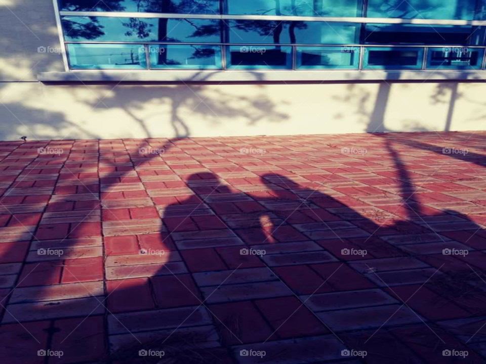 a shadow of a mother tapping the back of her daughter as a comfort.