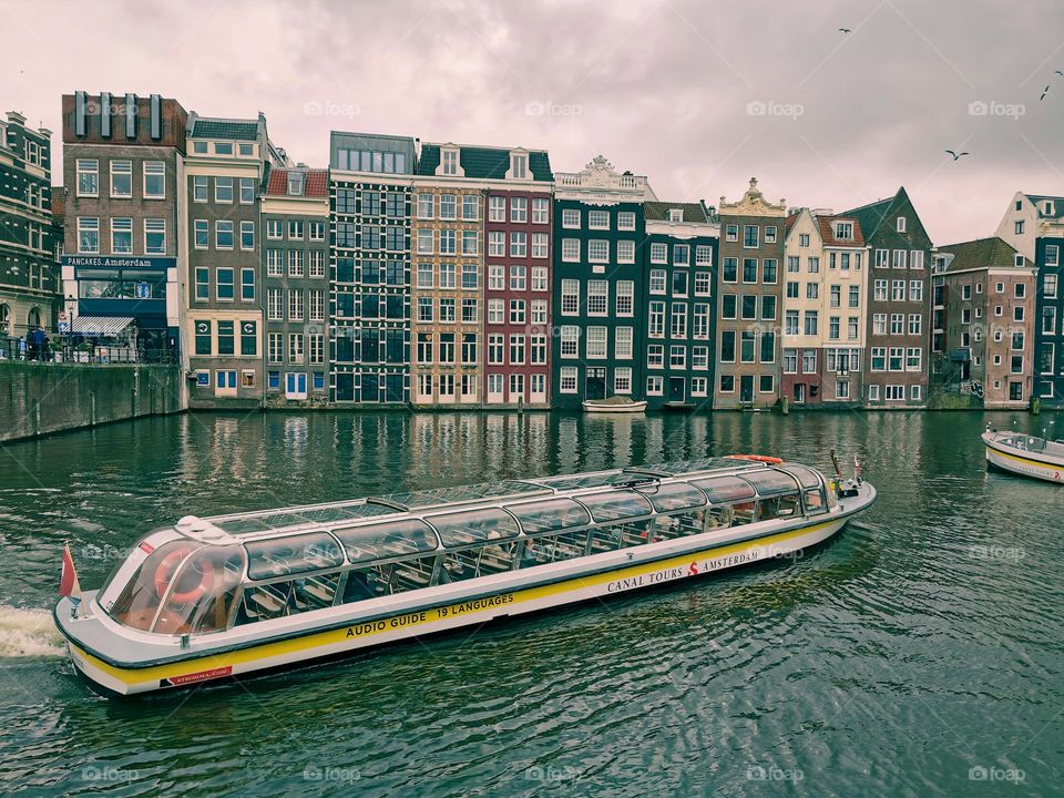 Amsterdam City with boat at canals with colorful buildings