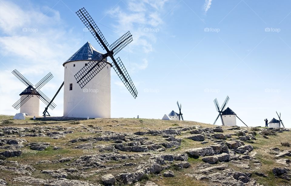 A person takes photos of traditional windmills in Spain