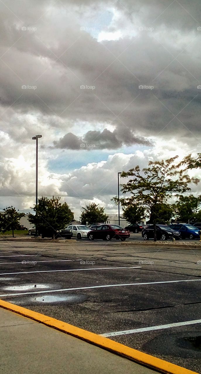 big fluffy clouds above a parking lot