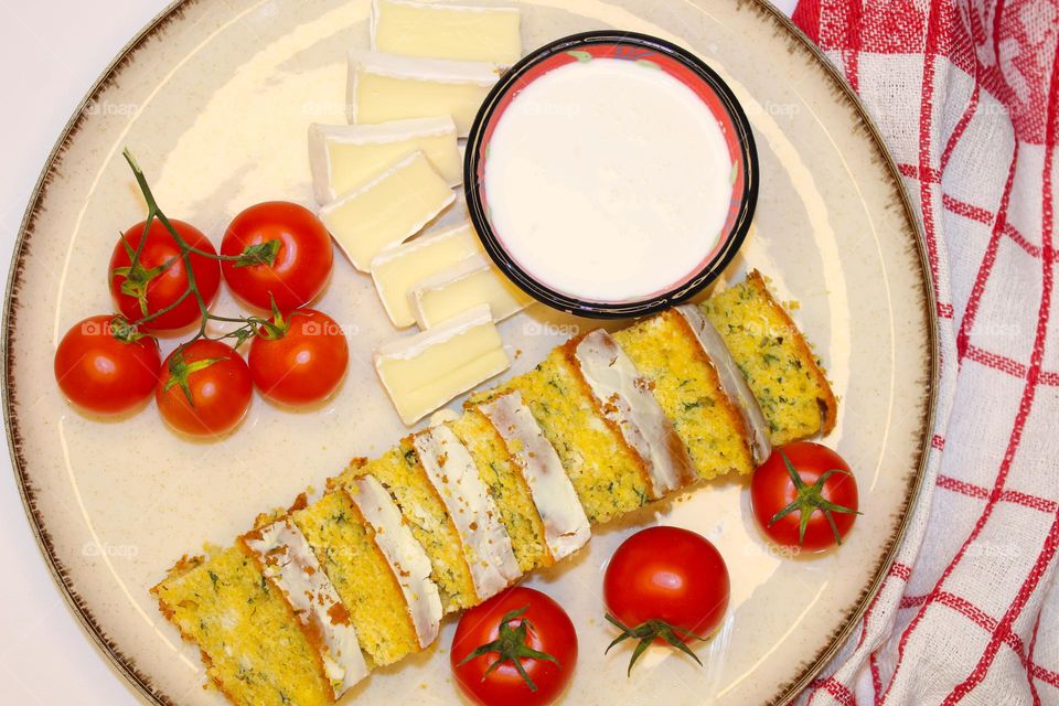 Vegetarian breakfast.  Cornmeal pie with cheese and spinach, brie cheese,  cherries , and yogurt