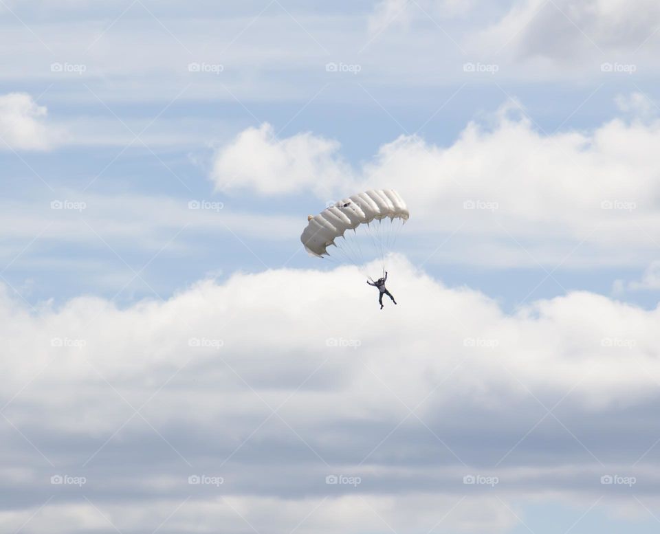The parachute is flying against the blue sky. Parachuting.