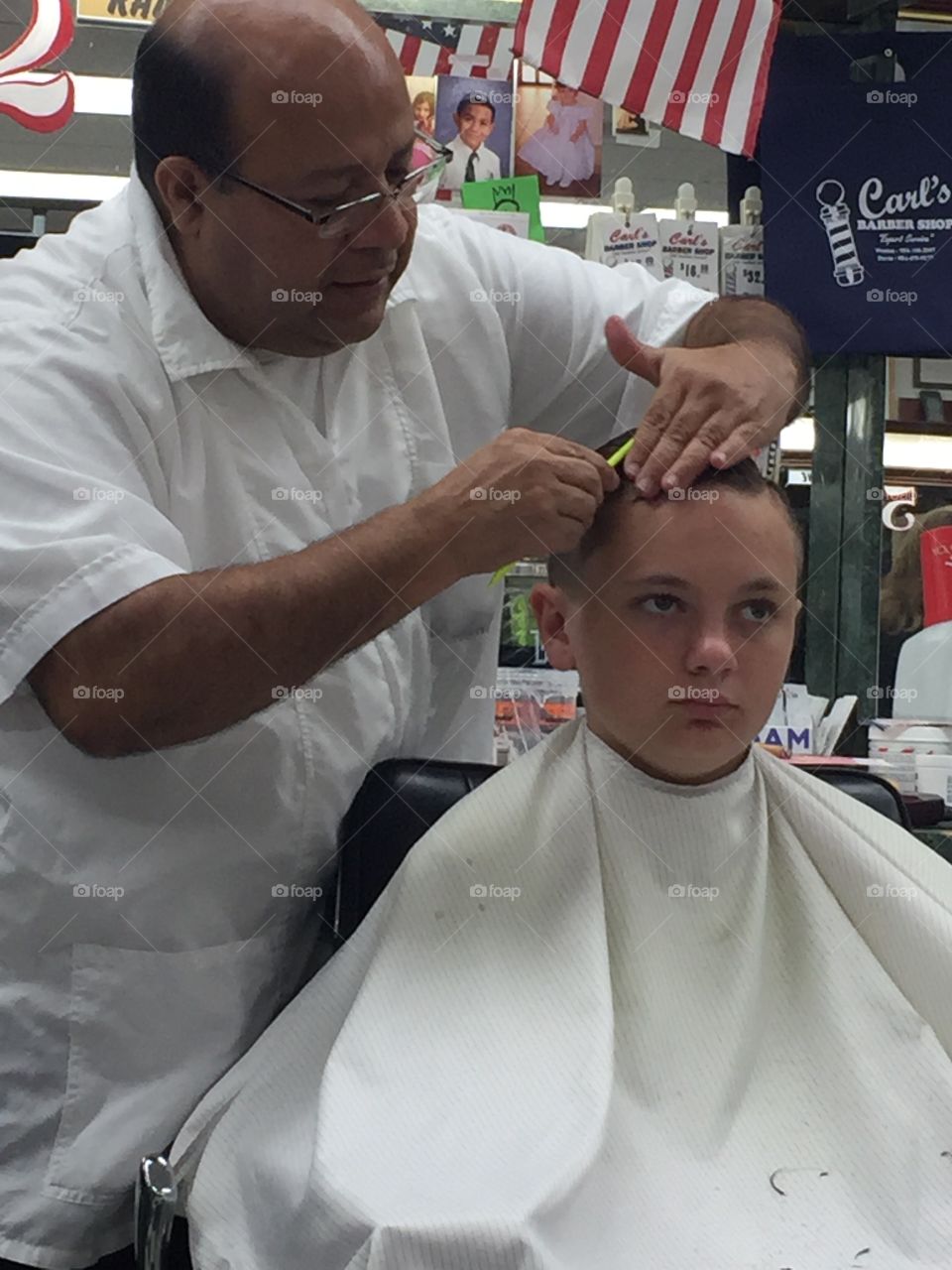 Hairdresser cutting the boys hair in salon