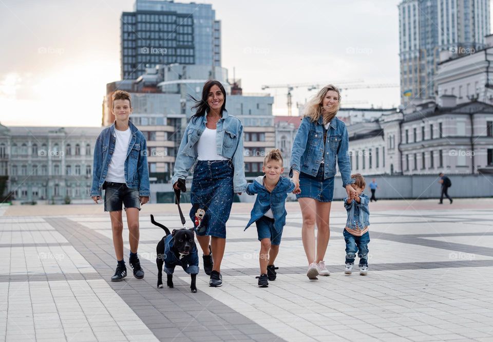 walking the dog down the street, the owner walks the weakling, teaches her, cleans up after her, educates, plays with his pet. people and dogs are best friends, beautiful big family together