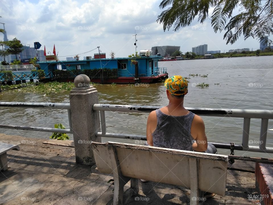 Man by the river. Houseboat. Saigon River. Ho Chi Minh City