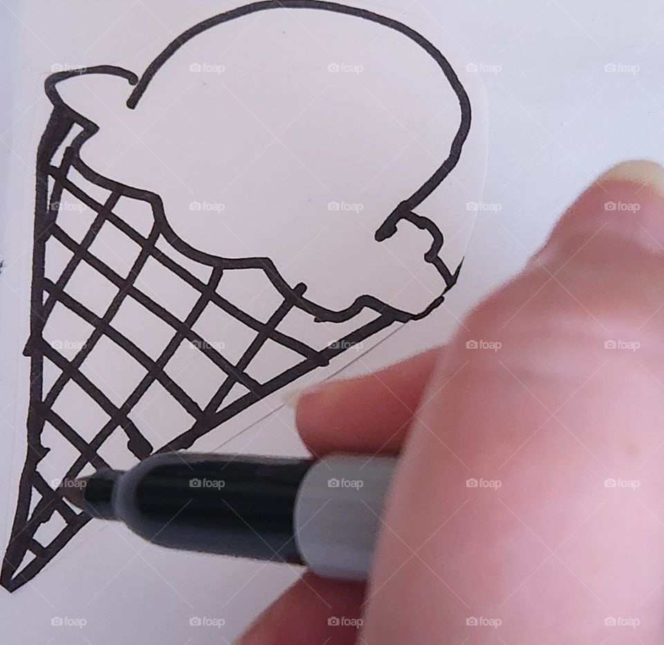 hand drawing an ice cream cone as the artist daydreams about refreshing sweet treats