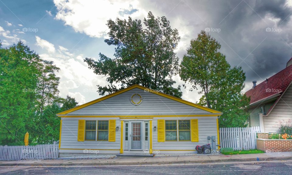 Architecture. White House With Cheery Yellow Shutters