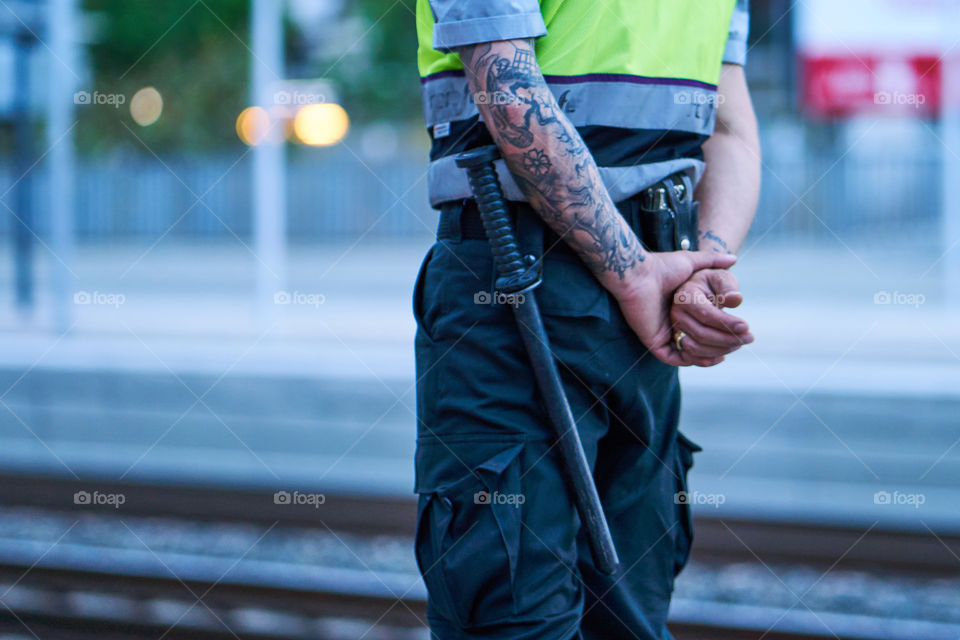 Guardia de Seguridad con un diablo tatuado en el brazo