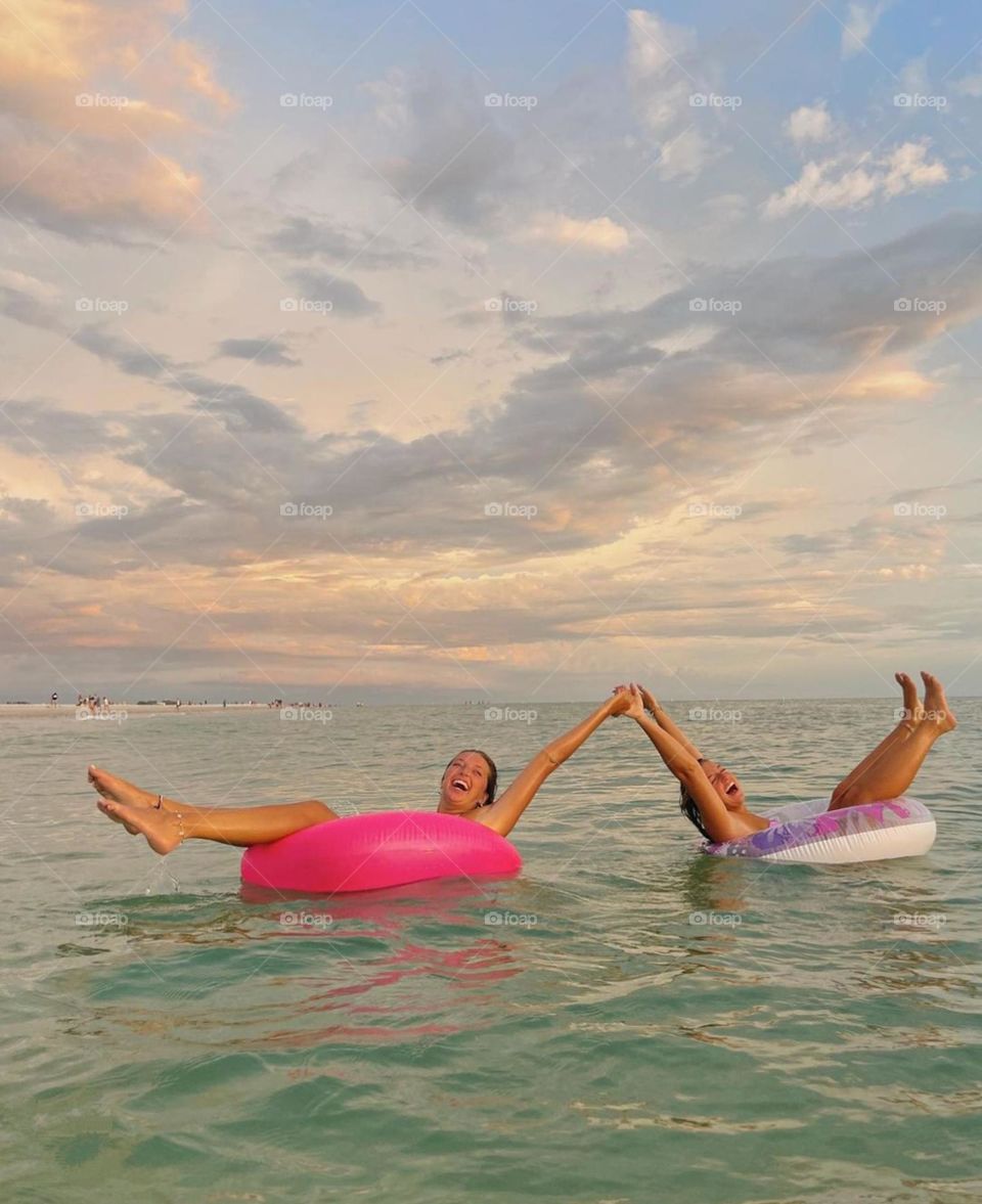 girls swim in the sea with inflatable circles