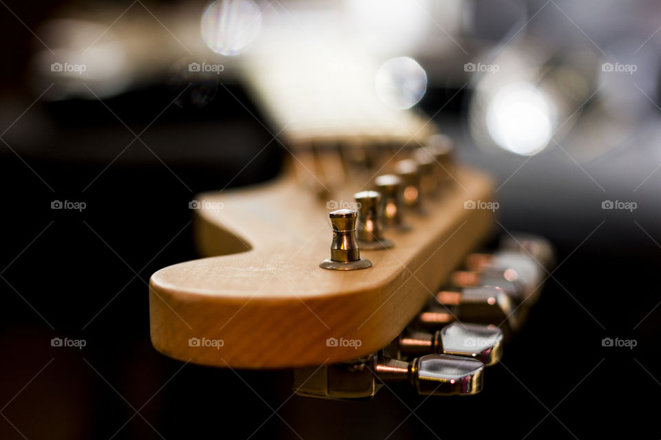 The headstock of a guitar with the machine heads and an insane shallow depth of field and some nice bokeh.