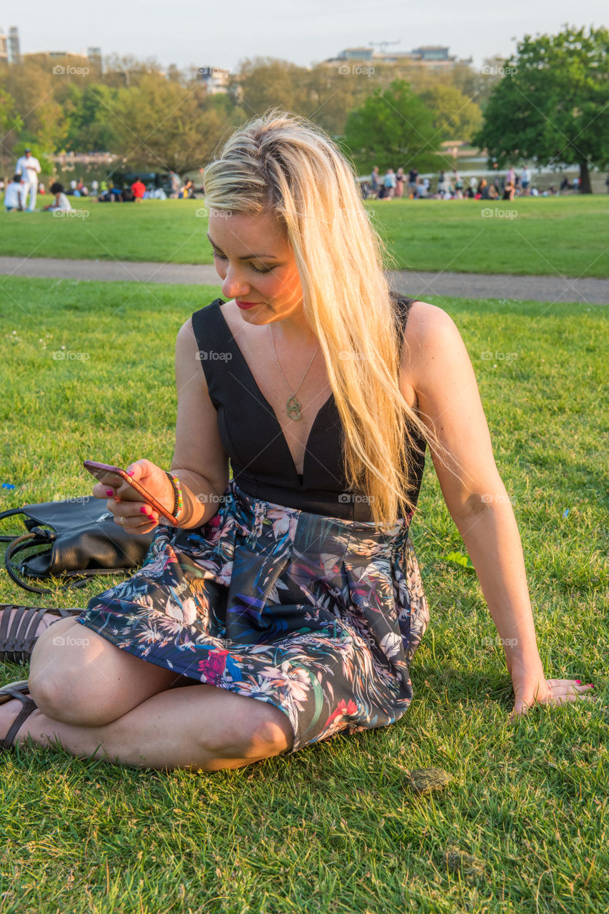 Woman tourist from Sweden 30 years plus taking a selfie in Hyde park in London.