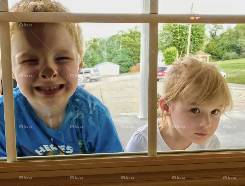 Boy and girl looking through the window 