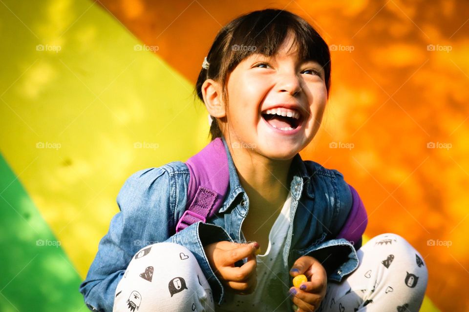 Happy laughing girl with a rainbow background