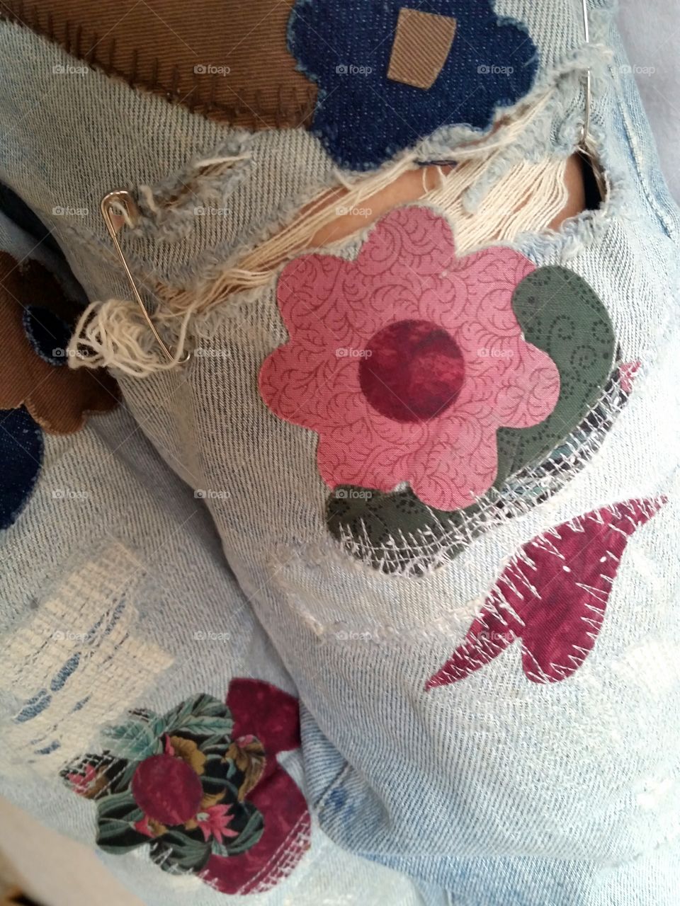 ripped jeans with patch design and safety pins
