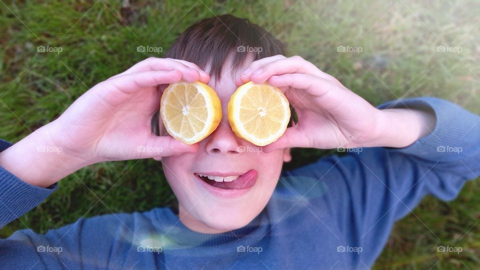 smiling boy is lying on the grass