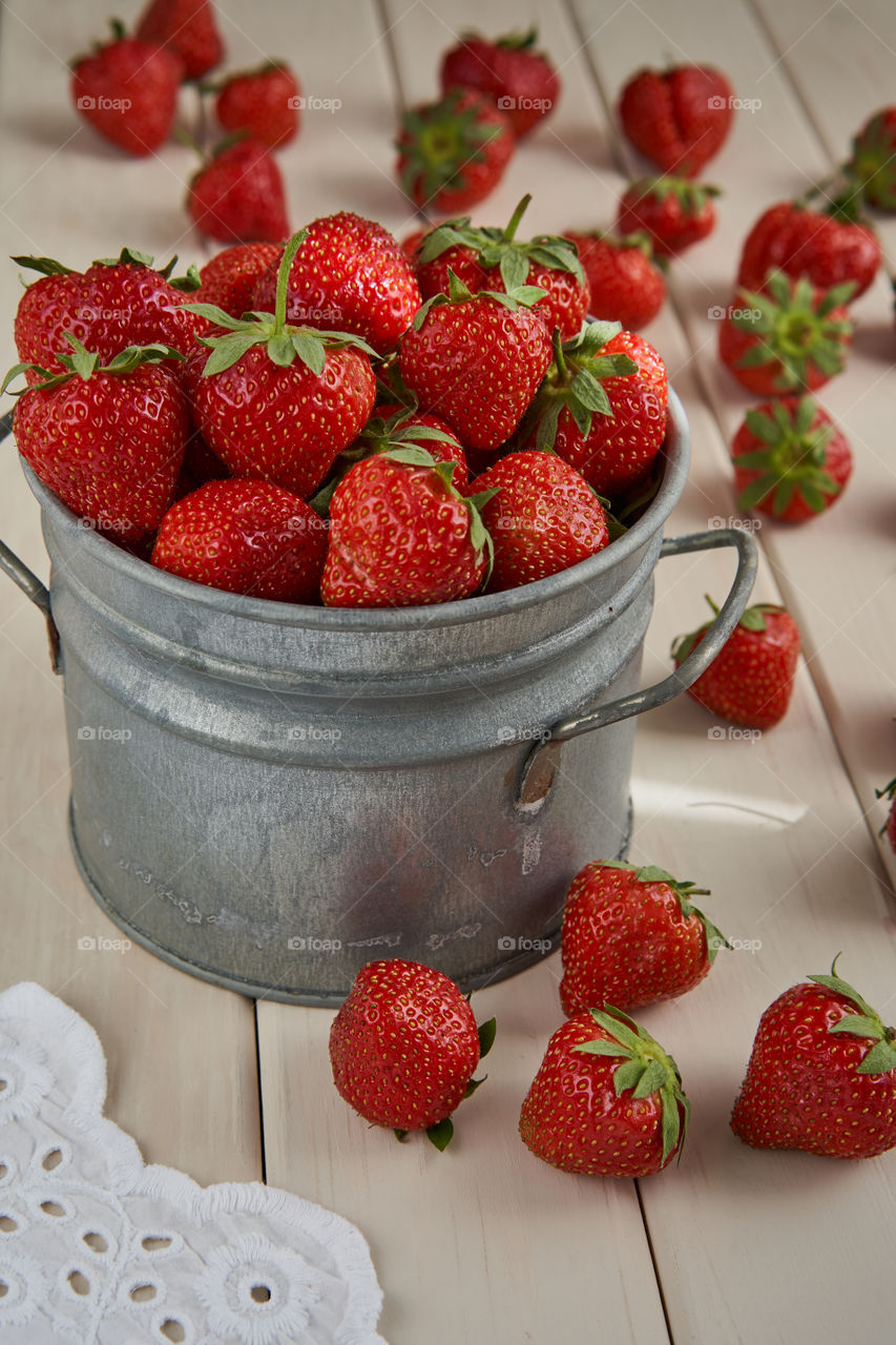 A vintage pail full of freshly picked strawberries 