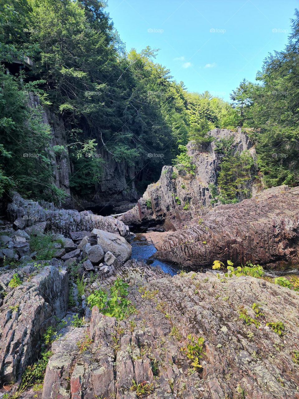 Rocky cliffs with a small stream of water flowing through.