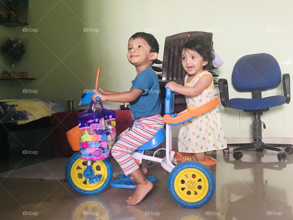 Brother and sister cycle riding with cheerful faces 