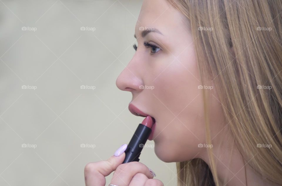 woman paints her lips with lipstick