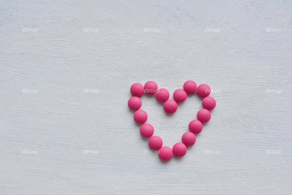 pink heart pills vitamins top view white background