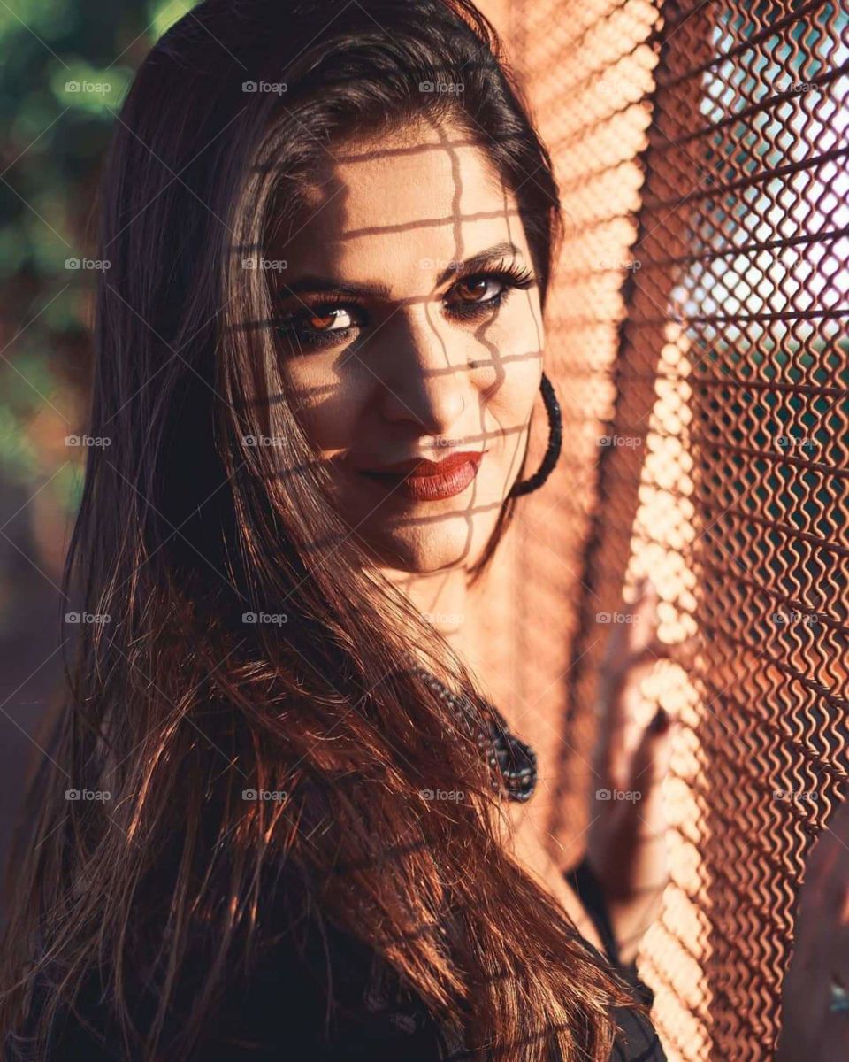 shadow of the gate screen on the face of a pretty woman