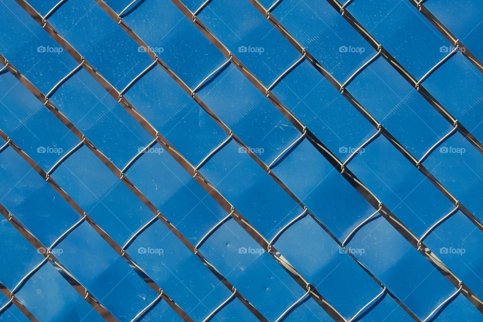 A closeup of a fence with plastic weave.