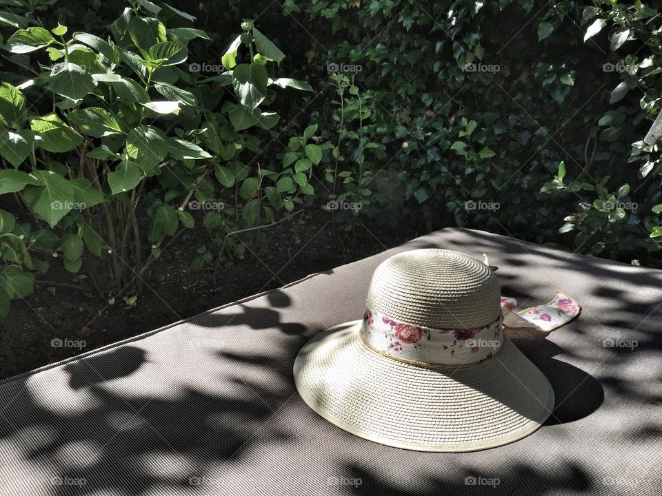 Sun hat on a sun bed. Enjoy sunny days with a mixture of shadow and light.