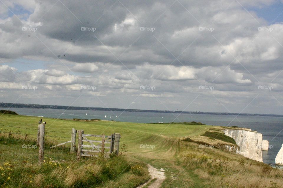 Countryside landscape of green fields blue sea and cloudy sky Dorset uk