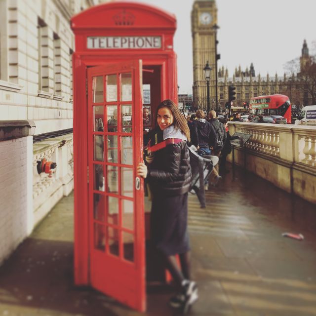 Woman smiling while entering phone booth