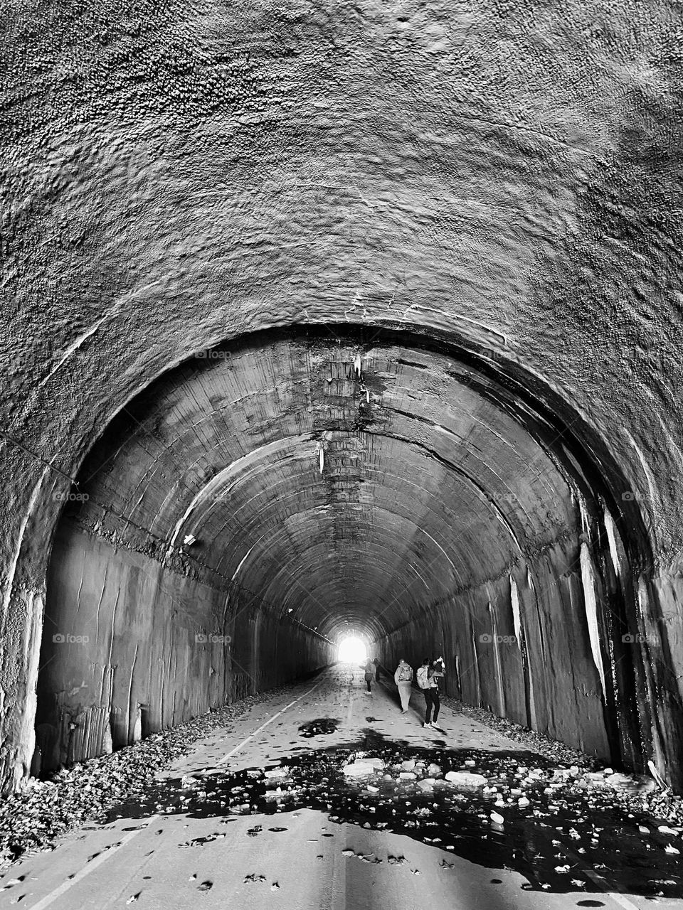 A group of people taking pictures and walking through the Borden Tunnel, part of the Great Allegheny Passage trail 