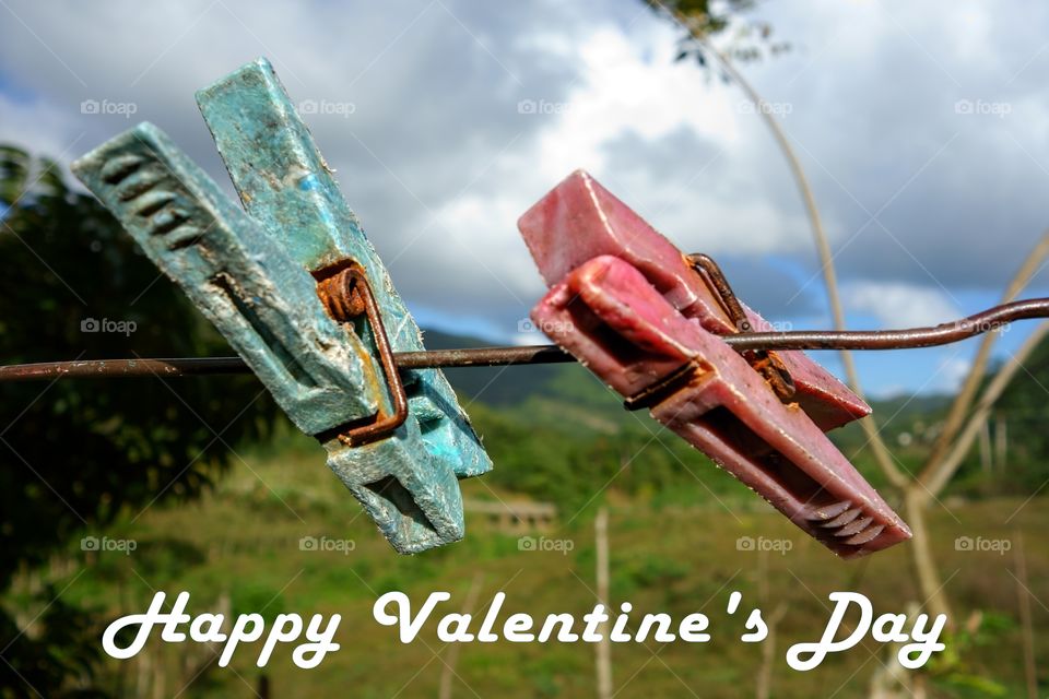 Valentine's Day greetings featuring two aged clothespin in tropical setting in Cuba
