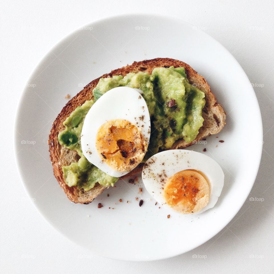 Avocado toast and boiled egg on a white plate