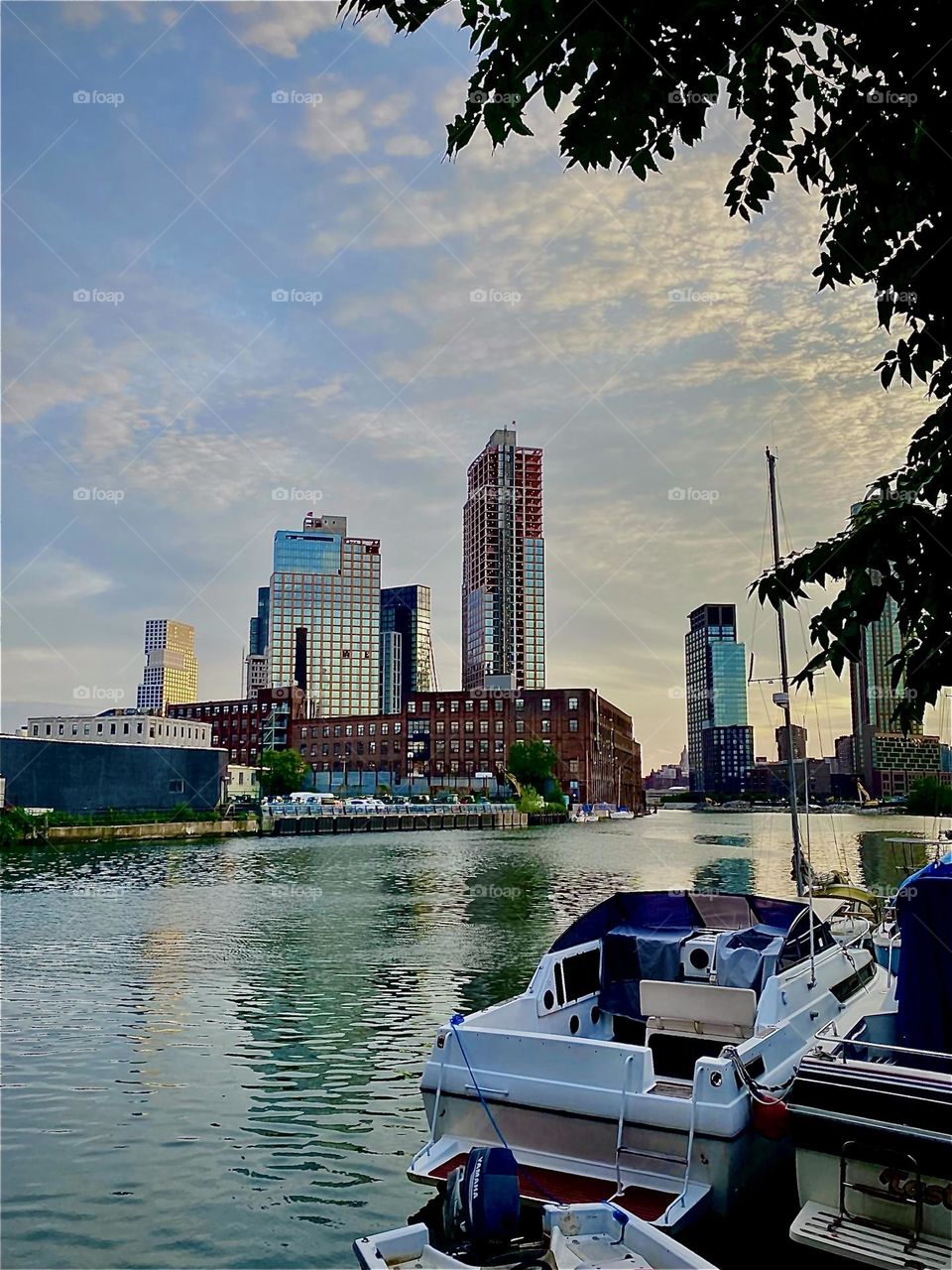 A charming impression of „Newtown Creek“ as seen from beneath the „Pulaski Bridge“ at the spot by the wall we usually climb to get to our boat, the „Salvation“. The „East River“ is shimmering as the sun sets behind the horizon. 2022. Hypnotic Prod