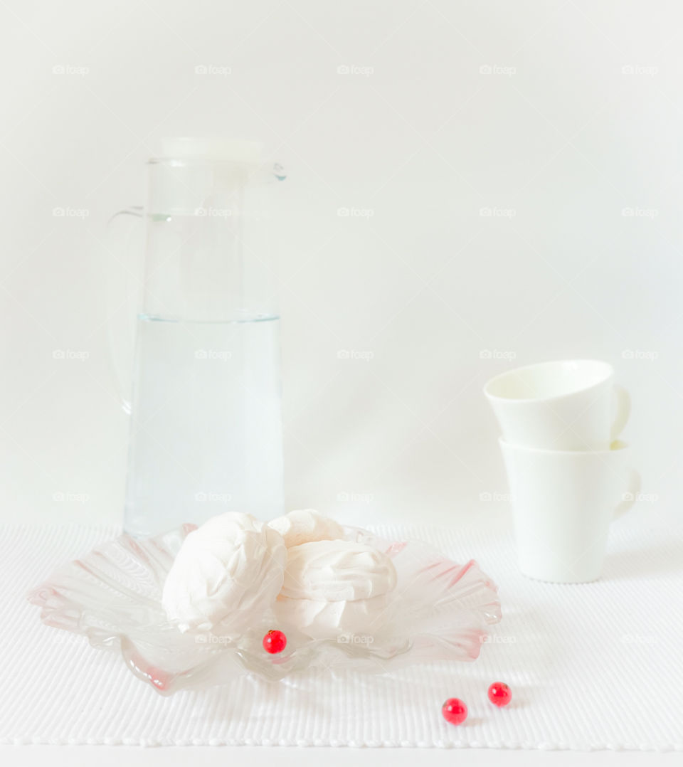 Fluffy white marshmallow in blue round bowl on old wooden table with copy space close up