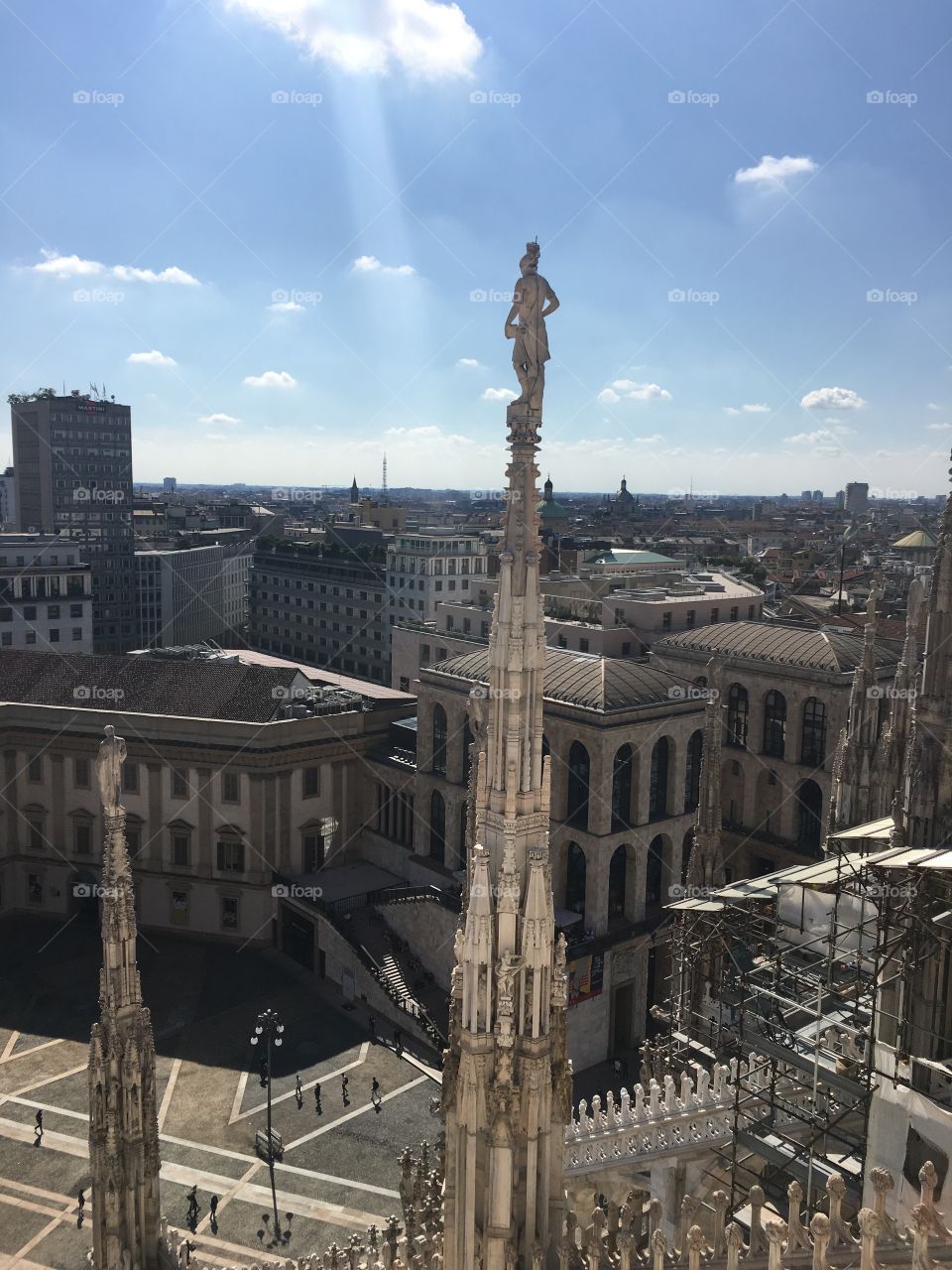 View of Milan from atop Duomo with Saint over city, ray of light onto city