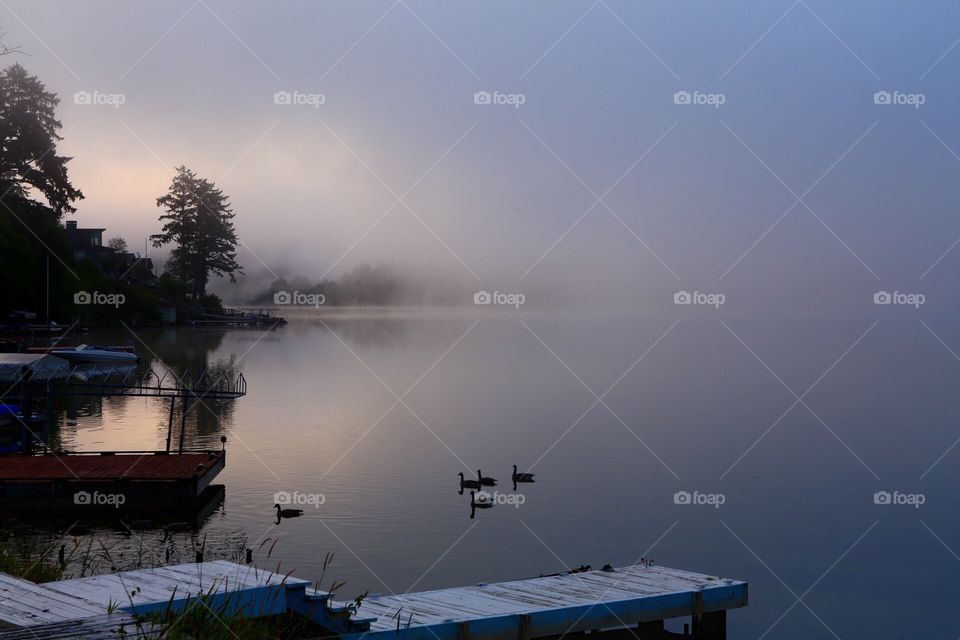 Early morning mist rises like smoke from the waters of Devils Lake, Oregon